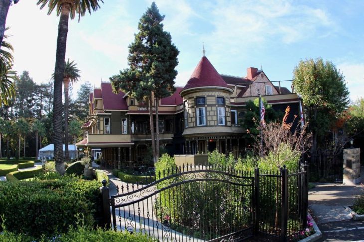 A serene garden surrounding the Winchester Mystery House, offering a tranquil atmosphere.